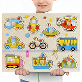 Child holding a wooden puzzle with various transportation-themed pieces.