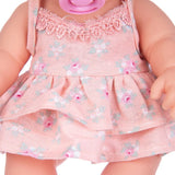 Close-up of a doll wearing a pink floral dress.