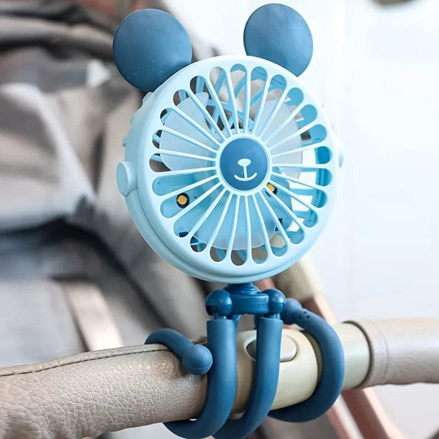 Blue handheld fan with silicone handles attached to a railing.