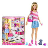 Barbie doll with pet and accessories next to her packaging