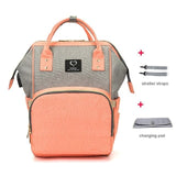 Peach and gray backpack with stroller straps and changing pad on a white background