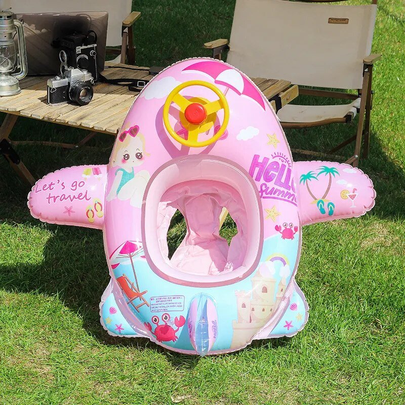 Pink inflatable airplane seat for children on grass with outdoor furniture in the background