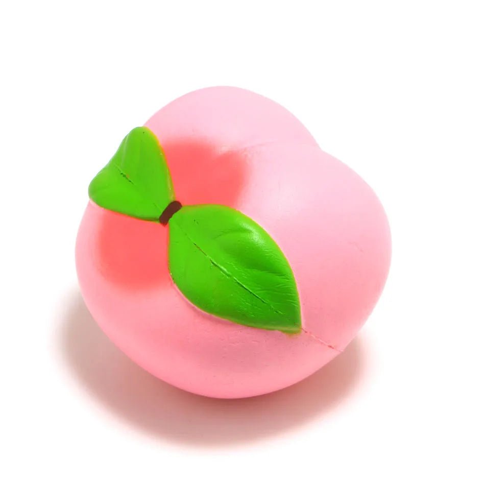 Pink peach-shaped object with a green leaf on a white background