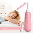 Pink water flosser with a woman lying on a bed in the background