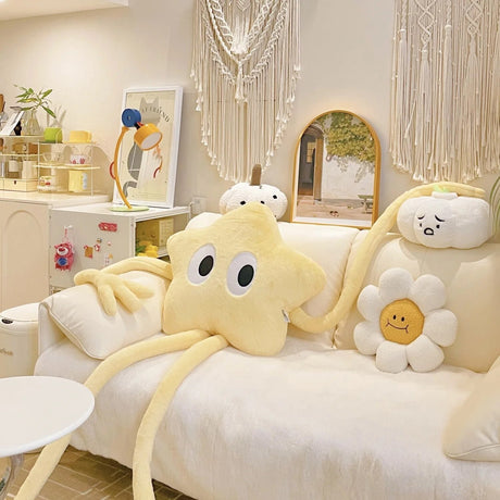 Decorative pillows shaped like a star, cloud, and flower on a white sofa in a room with a mirror and lamp.