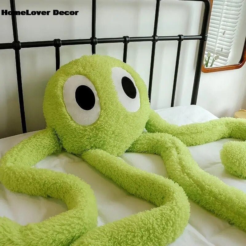 Green plush octopus toy on a bed with 'HomeLover Decor' branding.
