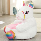 Plush unicorn toy with rainbow colors on a wooden floor.