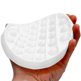 Hand holding a white silicone mold with a textured surface.