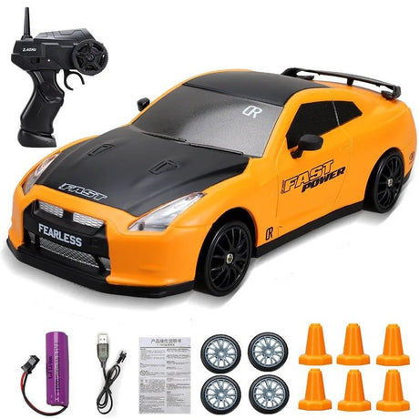 Orange toy car with black hood and 'Fast Power' branding, accompanied by a remote control and accessories 