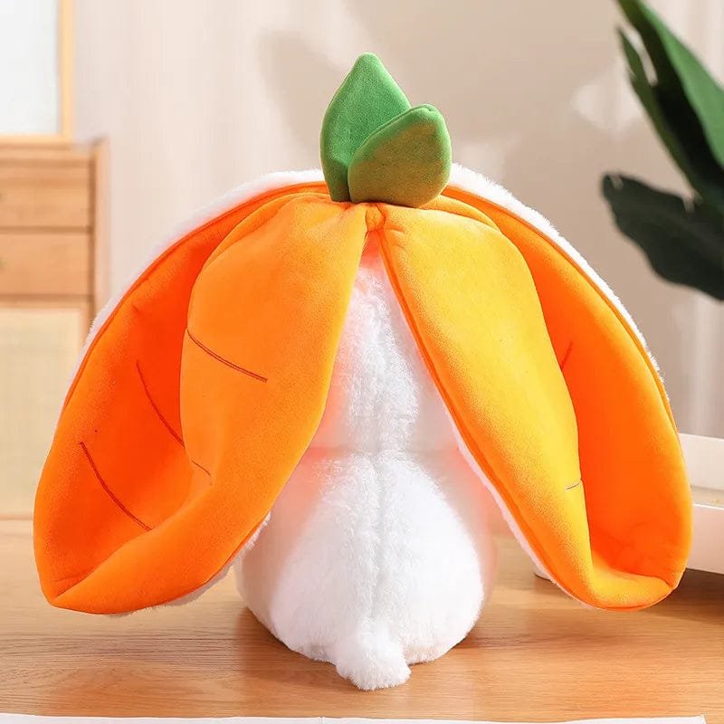 Plush toy shaped like a pumpkin with a white base on a wooden surface.