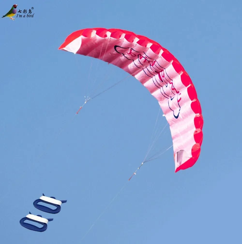 Red and white kite with blue strings against a clear blue sky