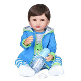 Child's toy doll wearing a blue outfit with a green hood and striped pants, holding a bottle.