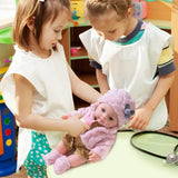 Two young girls playing with a baby doll in a colorful playroom.