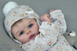 Baby in a patterned outfit.