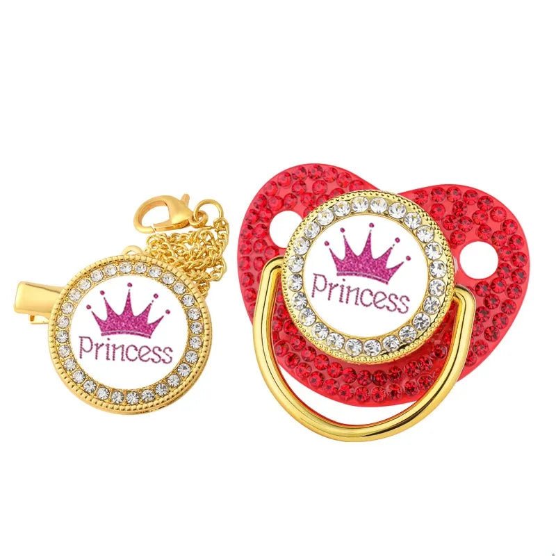 Red pacifier with gold and rhinestone details and a 'Princess' design on a white background.