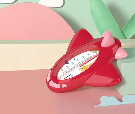 Red thermometer shaped like a cat with pink ears on a colorful background