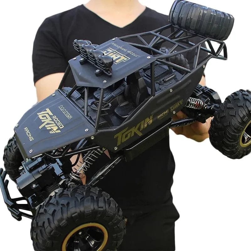 Person holding a large black and blue toy truck with 'Tokin' branding 
