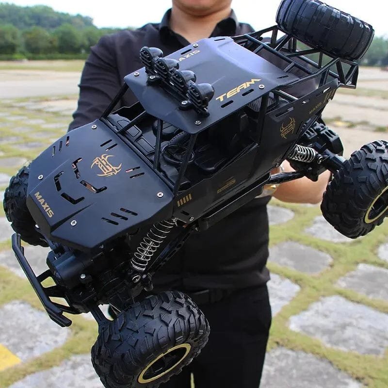 Person holding a large black remote control off-road vehicle with visible branding.