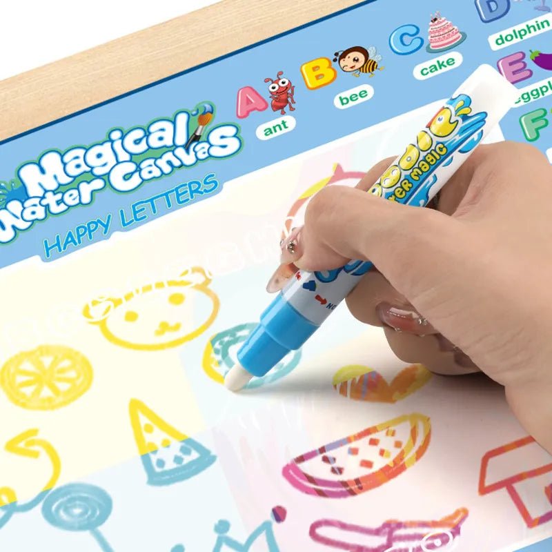 Hand using a watercolor pen on a 'Magical Water Canvas' with colorful drawings and letters.