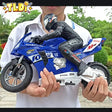 Person holding a blue toy motorcycle with visible branding
