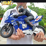 Person holding a blue toy motorcycle with visible branding