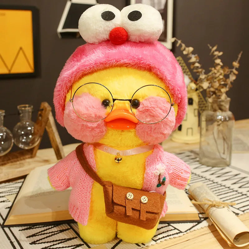 Plush toy duck wearing a pink hat and glasses on a desk