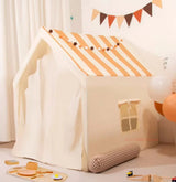 Children's play tent with striped roof and wooden toys on a light background