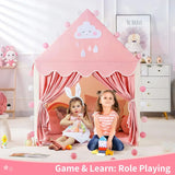 Two children playing inside a pink play tent in a room with toys and decor.