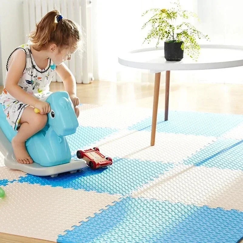 Child playing on a blue toy vehicle on a checkered floor mat.