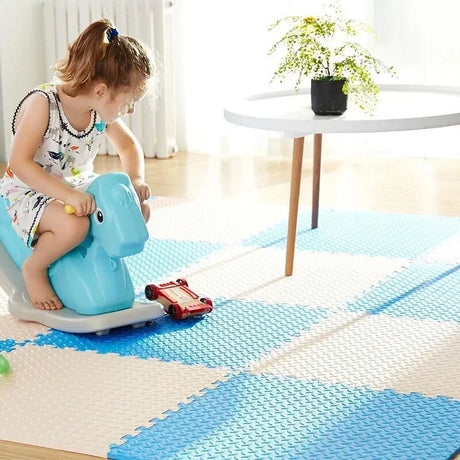 Child playing on a blue toy vehicle on a checkered floor mat.