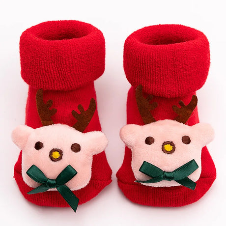 Red baby booties with reindeer faces on a white background