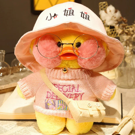 Plush toy duck wearing a pink hat and sweater with text, sitting on a surface.