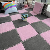 Pink and gray checkered foam mats in a room with decorative pillows and flowers.