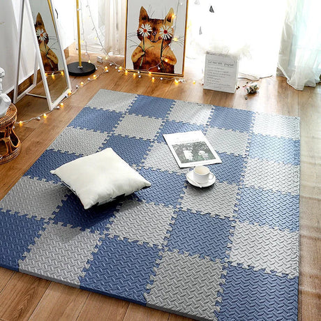 Checkered blue and gray rug on a wooden floor with a white pillow and small table.