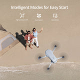 Drone on a sandy beach with two people and a tent, featuring intelligent modes text.