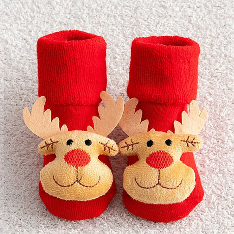 Red baby booties with reindeer faces on a textured white background