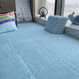 Bed with light blue bedding, decorative pillows, and a cityscape view from a window.