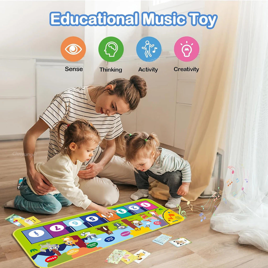 Woman and two children playing with an educational music toy on a wooden floor.