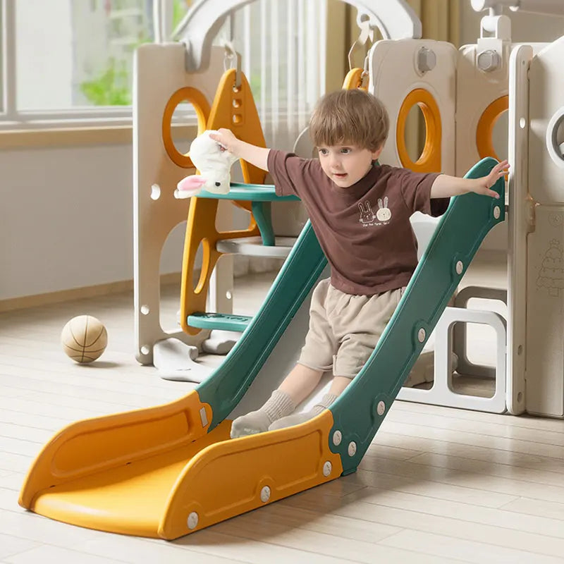 Child playing on a colorful indoor slide in a playroom.