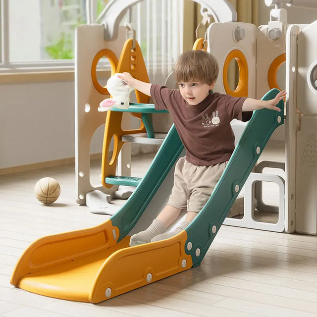 Child playing on a colorful indoor slide in a playroom.