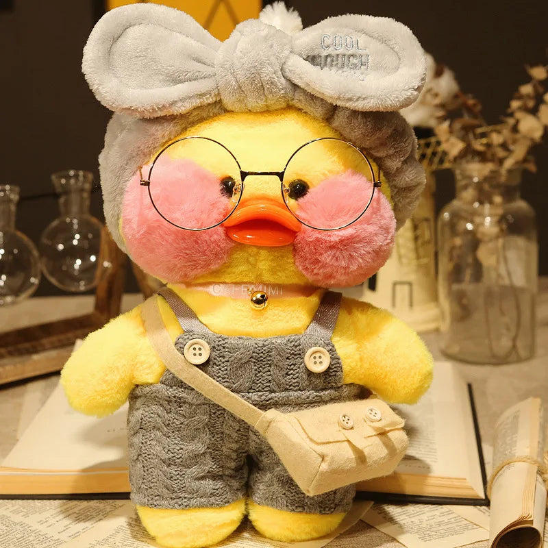 Plush toy duck wearing glasses and overalls on a table with books and jars.