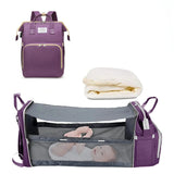 Purple baby travel bag with mattress and crib insert on a white background