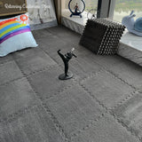Gray carpet with decorative items including a rainbow pillow and a small statue.