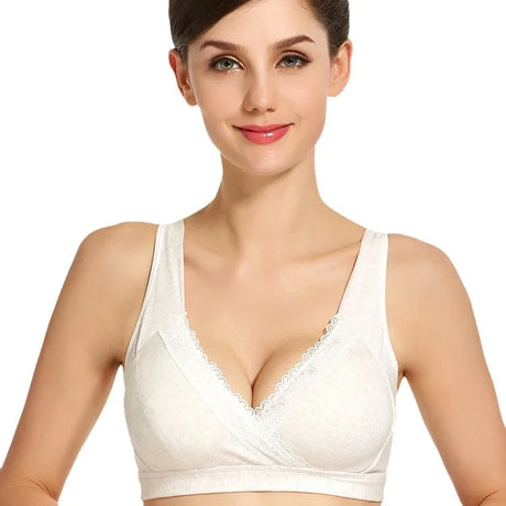 Woman wearing a white bralette on a plain background