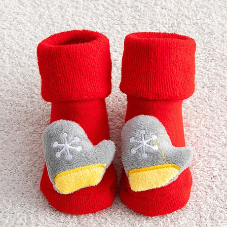 Red baby booties with gray mittens and yellow cuffs on a textured surface