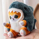 Plush toy shark with cat face held in a hand.