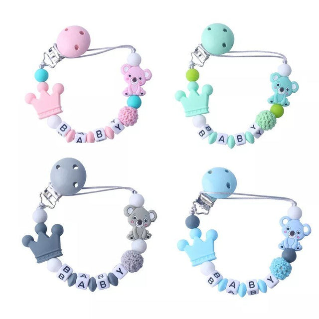Set of four colorful baby teething toys with 'BABY' letter beads on a white background