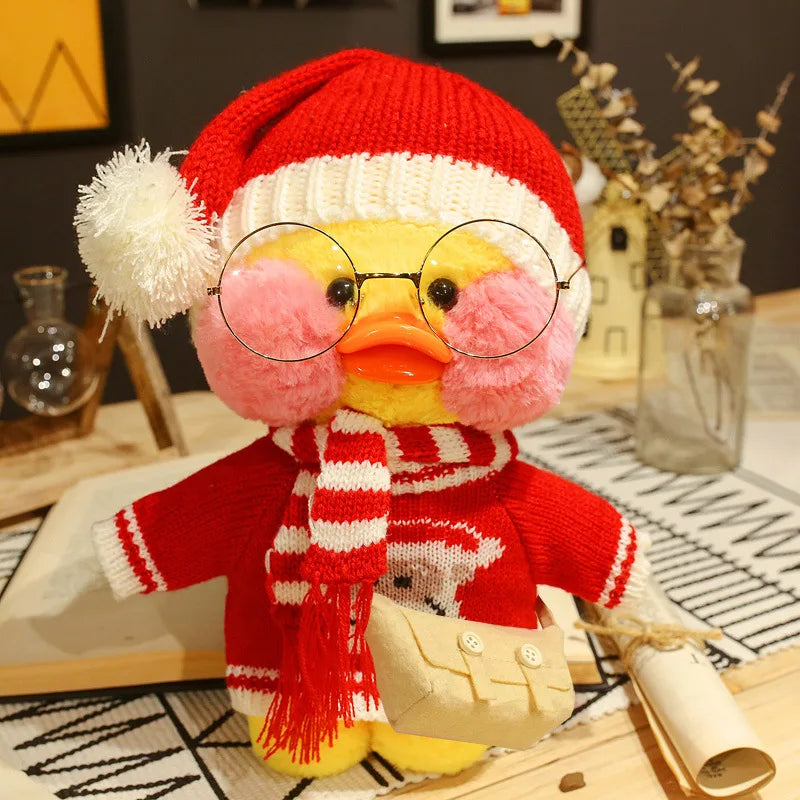 Stuffed toy duck wearing a red sweater, white scarf, and Santa hat on a decorative surface.