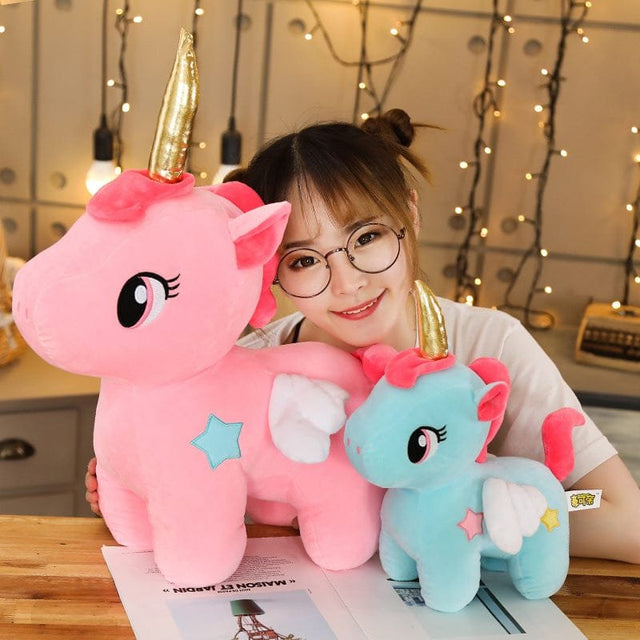 Person holding two plush unicorns.