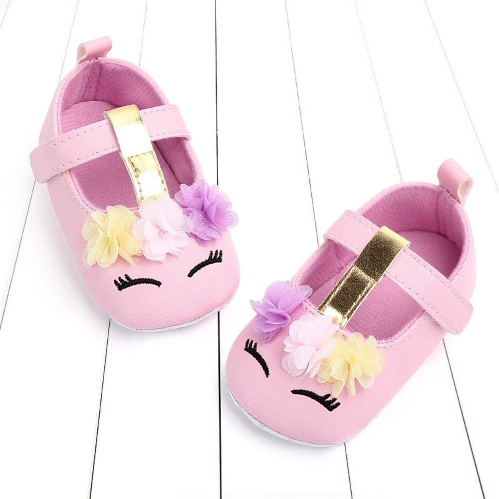 Pair of pink baby shoes with floral decorations